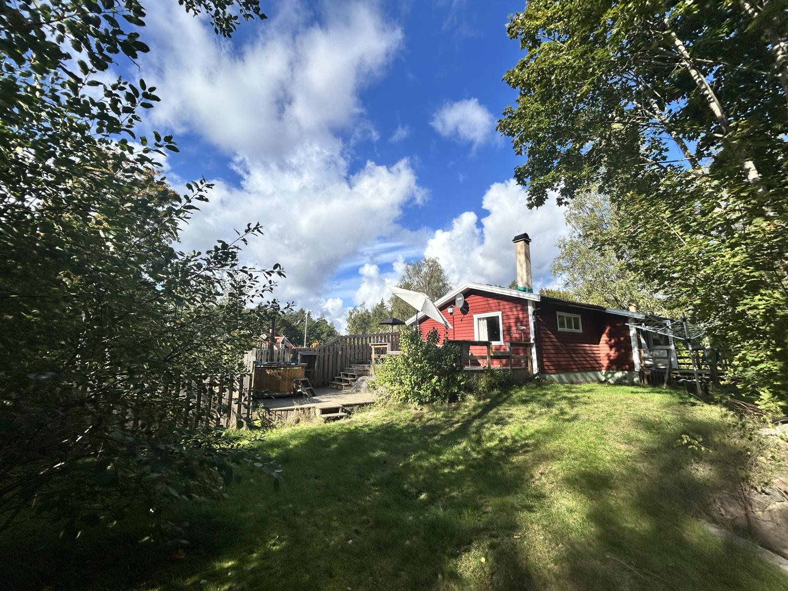 Das rote Ferienhaus mit Terrasse, vom Garten aus gesehen