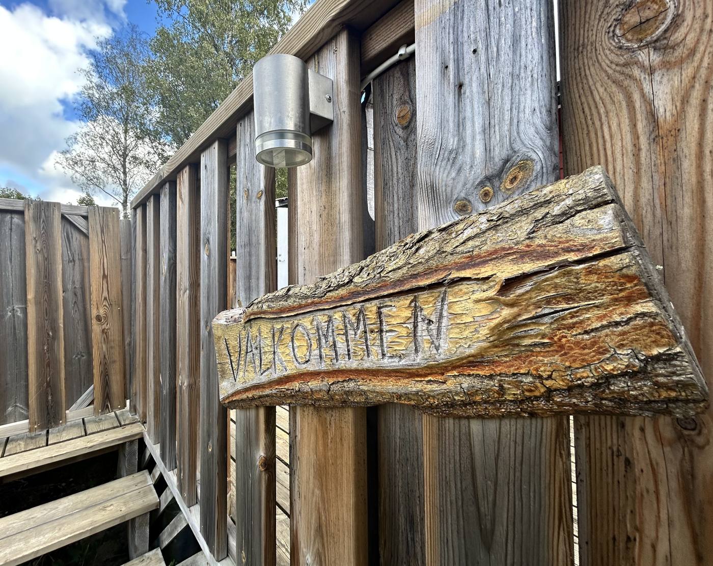 Holzschild „Välkommen“ am Eingang