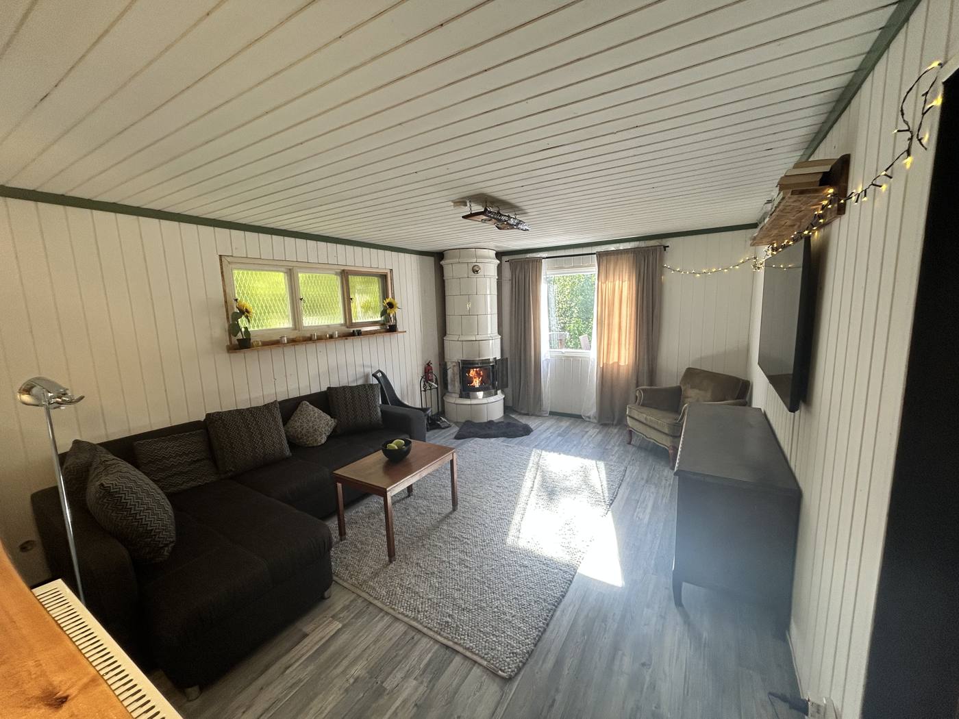 Wohnzimmer mit Ecksofa und Kamin
